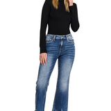 Blue denim kick crop flare jeans. The jeans have a high-waisted fit, are snug through the thigh, and flare out slightly above the ankle, showing the person's footwear.