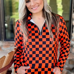 Orange and black checkered pullover with collared neckline, quarter-zip front, and kangaroo pocket, laid flat to show pattern and structure.