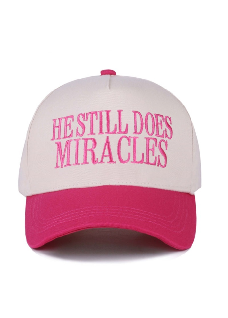 Fuchsia and white canvas cap with "He Still Does Miracles" embroidered on the front.