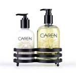 A 14 oz bottle of "Dazzle" hand wash and a 14 oz bottle of hand treatment sitting in a black sink-side caddy.