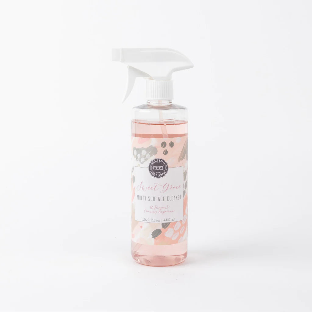 A pink spray bottle labeled 'Sweet Grace Multi Surface Cleaner' with a floral pattern.