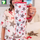 Simply Untamed 40 oz tumbler with a leopard star and bow print, featuring a built-in handle, reusable straw, screw-on lid, and car cup holder-friendly base. Stylish and functional drinkware for on-the-go hydration.