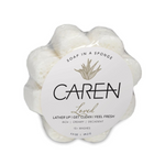 A daisy shaped, soap-infused sponge with the word "Loved" printed on the front.