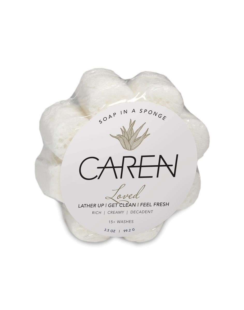 A daisy shaped, soap-infused sponge with the word "Loved" printed on the front.
