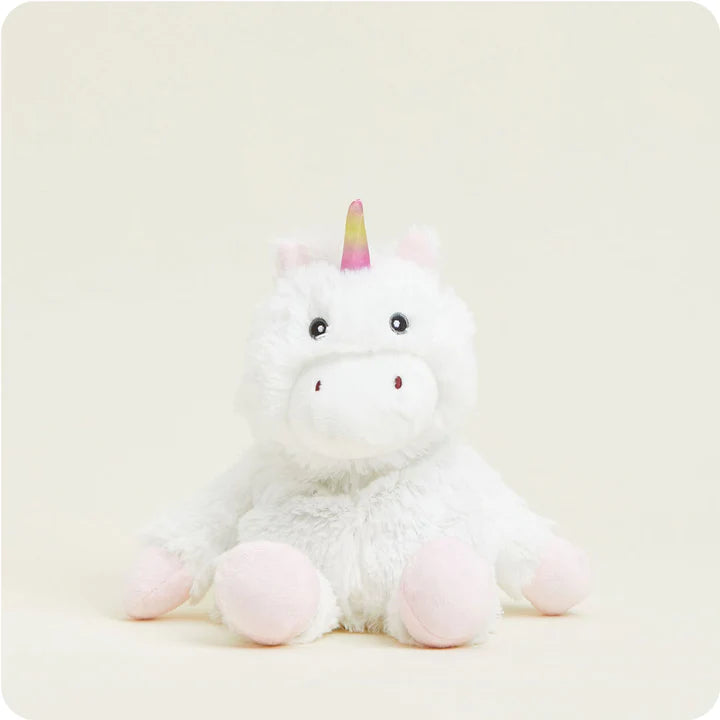 A small, soft plush white unicorn toy with a rainbow mane and tail and a sparkly horn, designed to be microwavable.