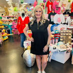 Black textured jacquard mini dress with quarter zipper neckline, side pockets, and high-low hem.