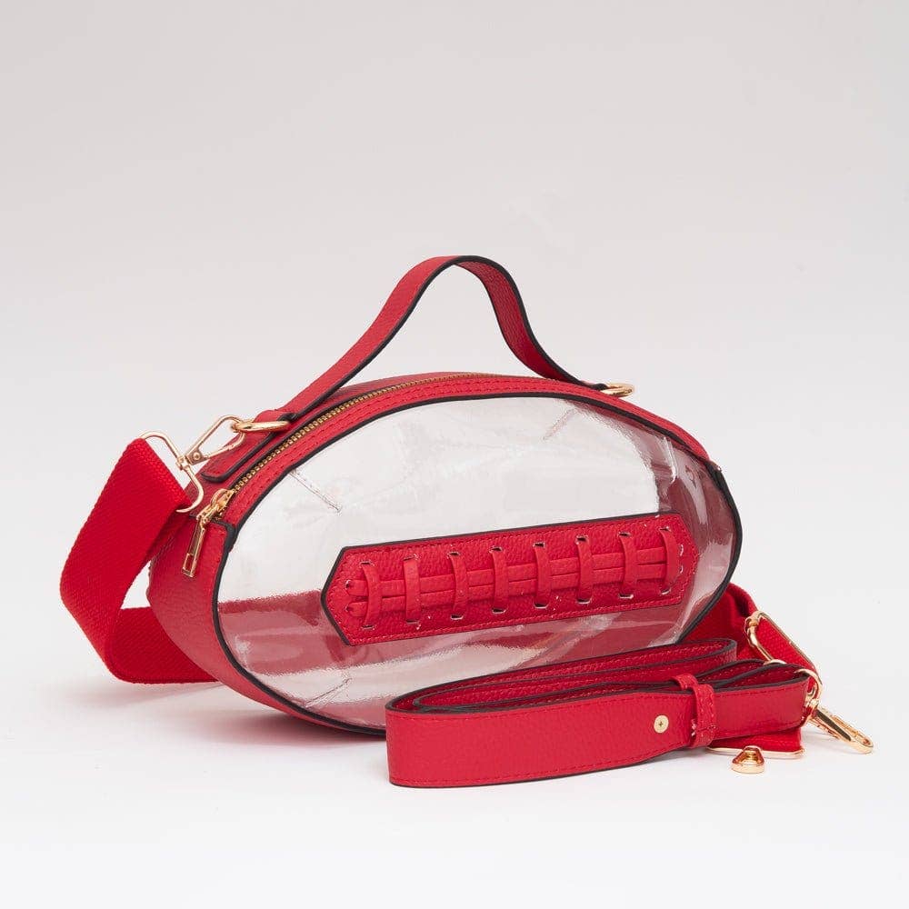 Red football-shaped crossbody bag with top handle, gold hardware, and adjustable strap, displayed to show shape and size.