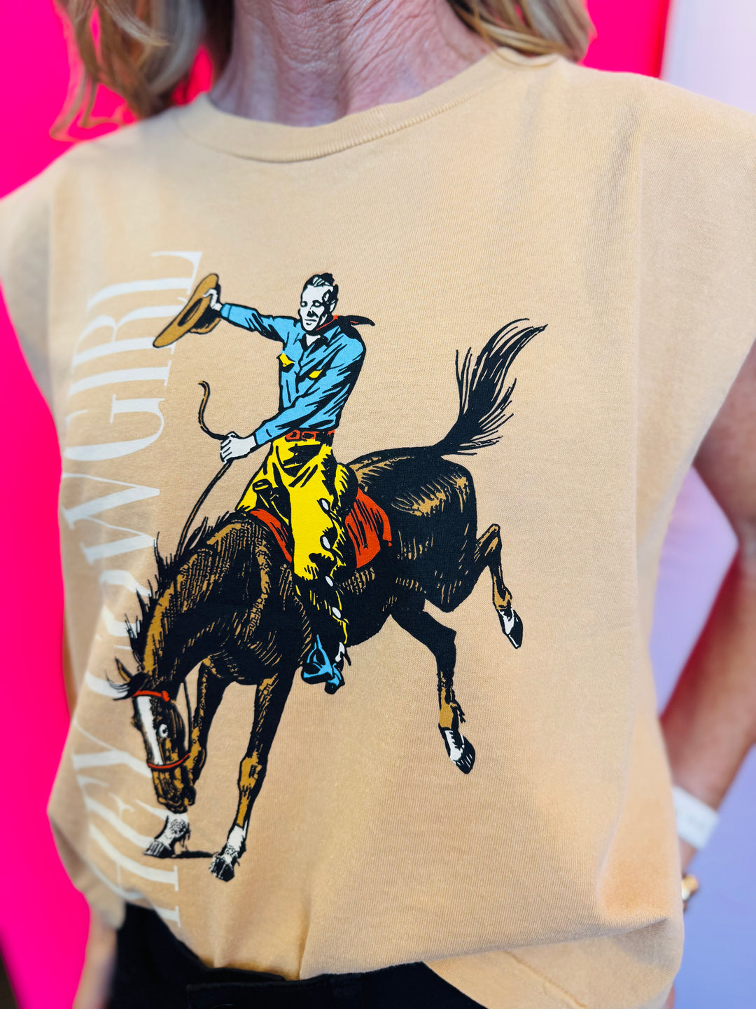 Front view of the Hey Cowgirl Cap Sleeve Tee in wheat color featuring bold cowboy-themed graphics for a trendy Western-inspired look