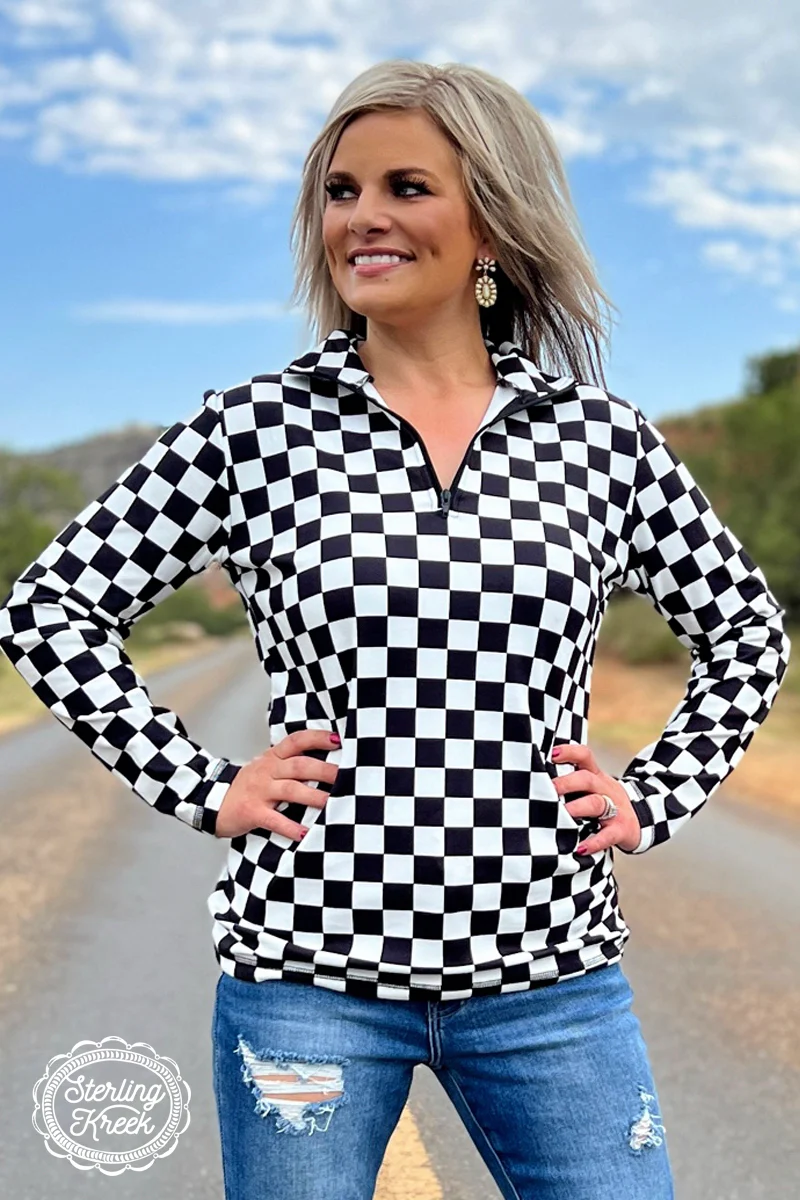 Black and white checkered pullover with collared neckline, quarter-zip front, and kangaroo pocket, laid flat to show pattern and structure.