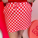 Red diagonal gingham skort with drawstring waist, side pockets, and built-in shorts for comfort.