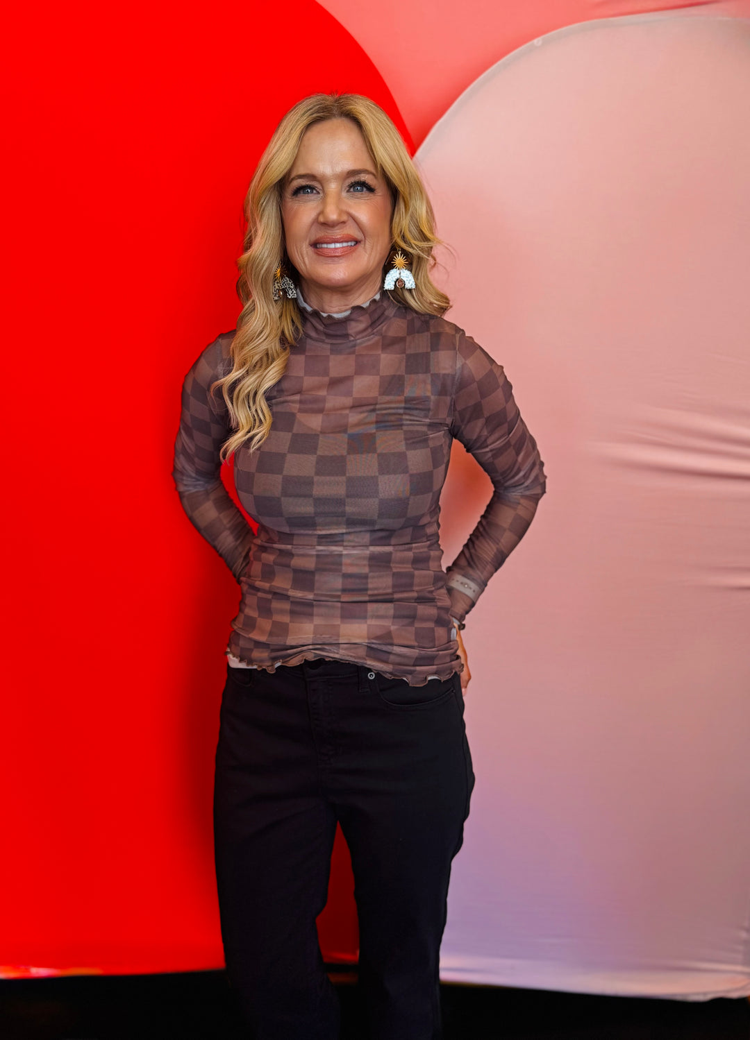 Front view of the Keigan Mesh Top in a chocolate checkered print, featuring a mock neckline, sheer mesh fabric, and lettuce-edge hems—perfect for layering or wearing solo with a tank underneath.