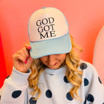 Baby blue and white foam trucker hat with “God Got Me” faith phrase.