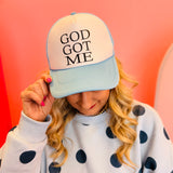 Baby blue and white foam trucker hat with “God Got Me” faith phrase.
