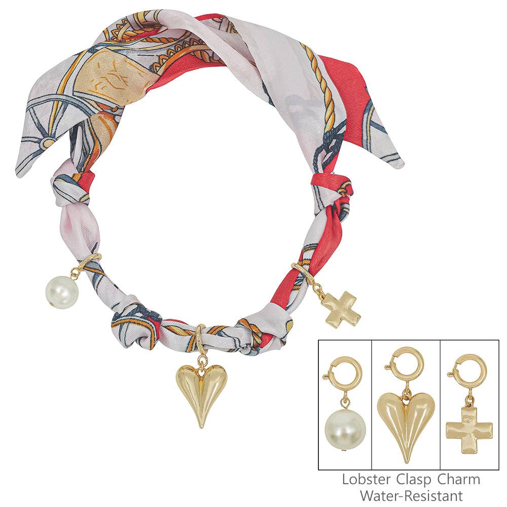 Red and white knotted scarf necklace with puffy heart, open cross, and bow charm.