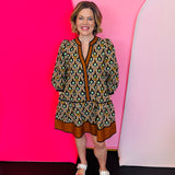 Geometric fall mini dress in orange, green, and gold with V-neck and ruffle hem.