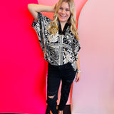 Black and white marbled bandanna print dolman sleeve top with a satin trimmed neckline.