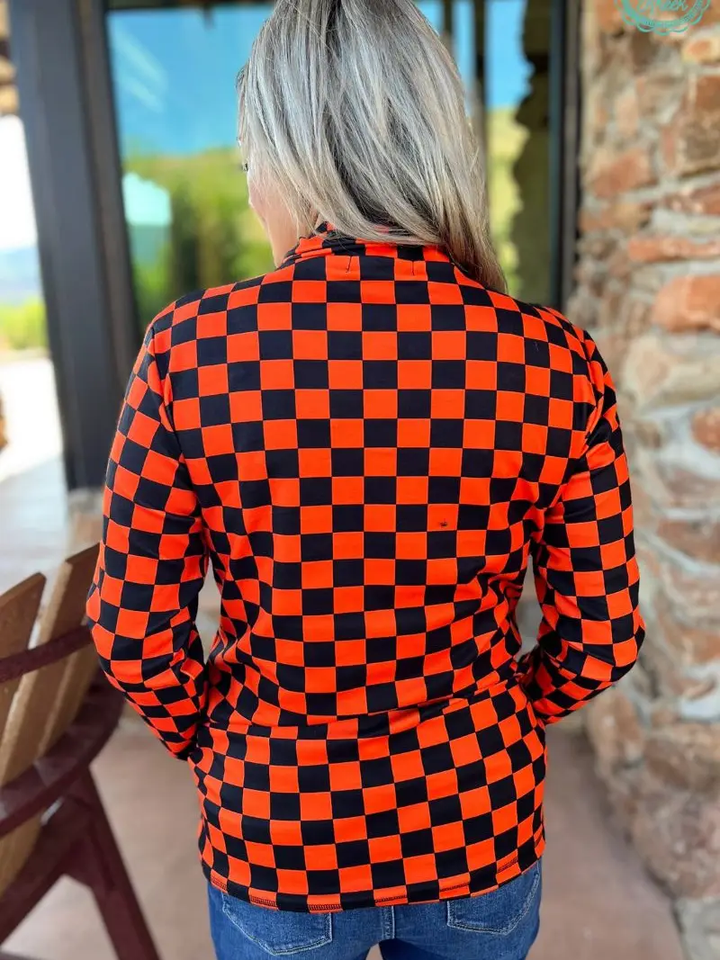 Orange and black checkered pullover with collared neckline, quarter-zip front, and kangaroo pocket, laid flat to show pattern and structure.