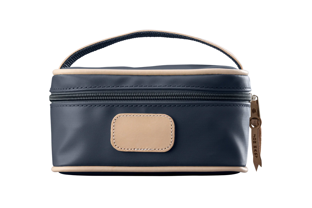 A charcoal colored Jon Hart mini makeup case with natural leather trim and a leather patch for personalization.
