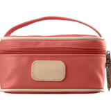 A coral colored Jon Hart mini makeup case with natural leather trim and a leather patch for personalization.
