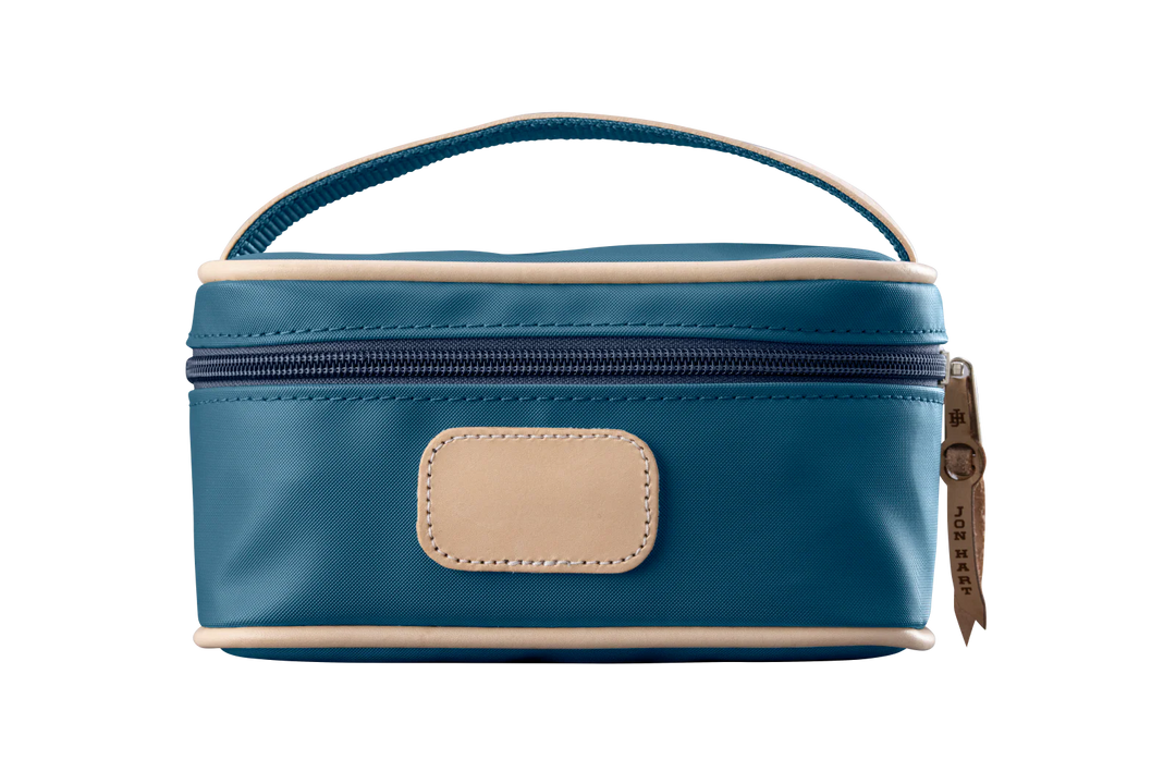 A french blue colored Jon Hart mini makeup case with natural leather trim and a leather patch for personalization.