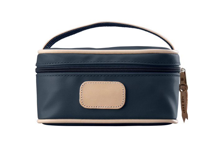 A navy colored Jon Hart mini makeup case with natural leather trim and a leather patch for personalization.
