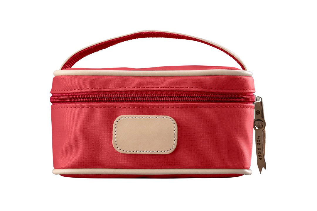 A red colored Jon Hart mini makeup case with natural leather trim and a leather patch for personalization.