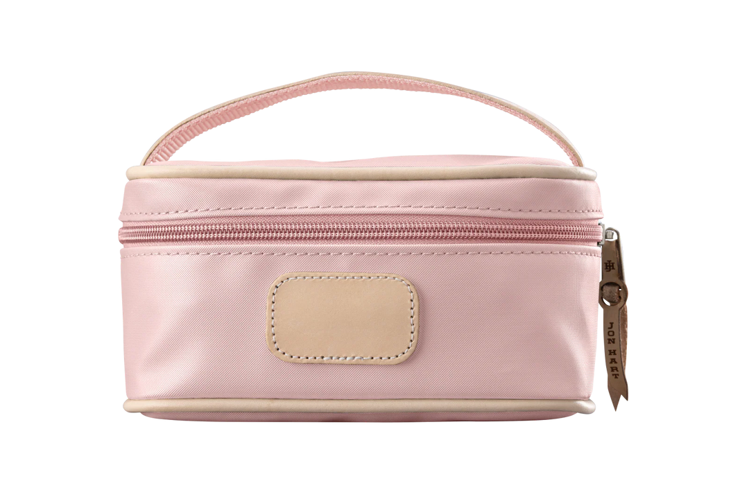 A rose colored Jon Hart mini makeup case with natural leather trim and a leather patch for personalization.