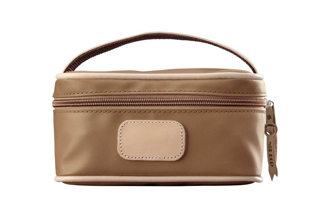 A saddle colored Jon Hart mini makeup case with natural leather trim and a leather patch for personalization.