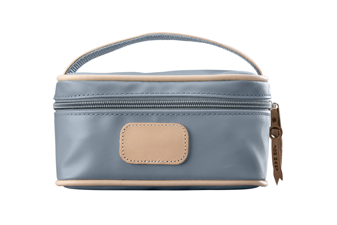 A slate colored Jon Hart mini makeup case with natural leather trim and a leather patch for personalization.