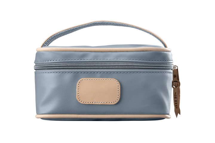 A slate colored Jon Hart mini makeup case with natural leather trim and a leather patch for personalization.
