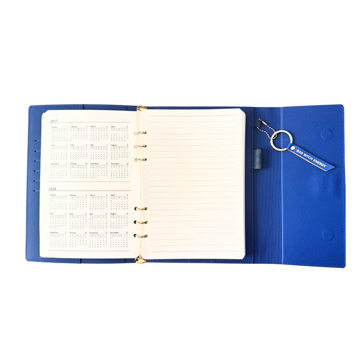 Calendar view of blue clutch journal folio and calendar with 'BAD BITCH ENERGY' text and colored pen.