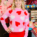 Pink sweater with red and white heart and pearl-embellished detailing.