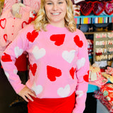 Pink sweater with red and white heart and pearl-embellished detailing.