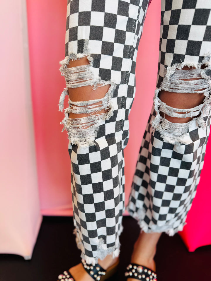 Knee view black and white cropped checkered jeans with knee distressing.