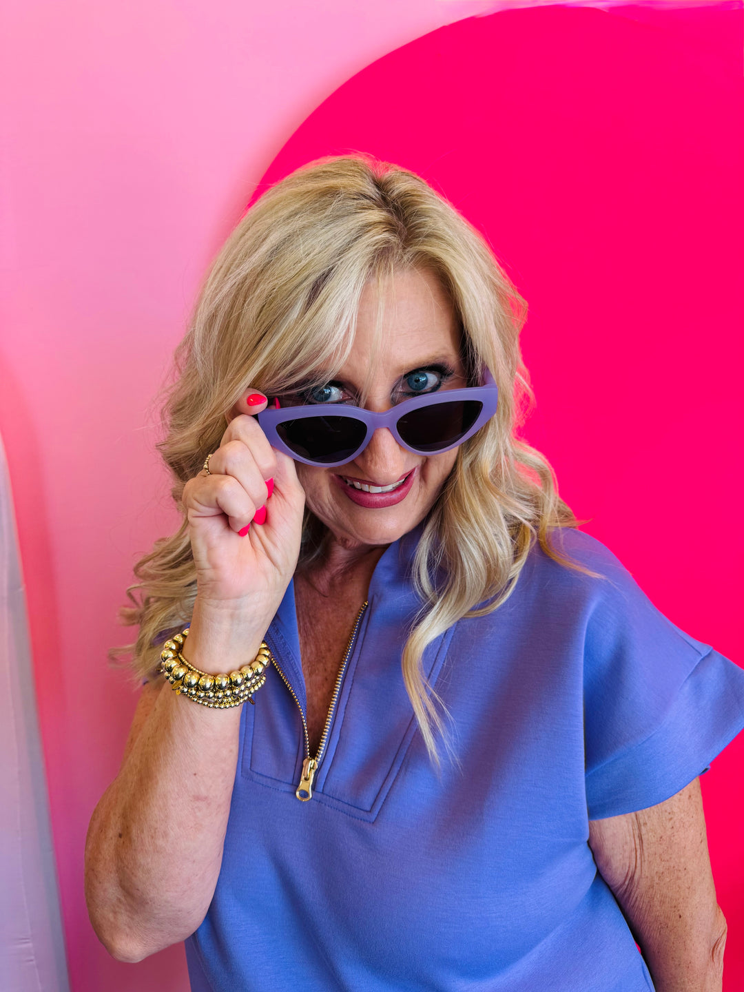 Model playfully posing with Dime Last Call Lavender Fog Polarized Sunglasses pulled slightly down, showcasing the sleek cat-eye shape and soft lavender frame.