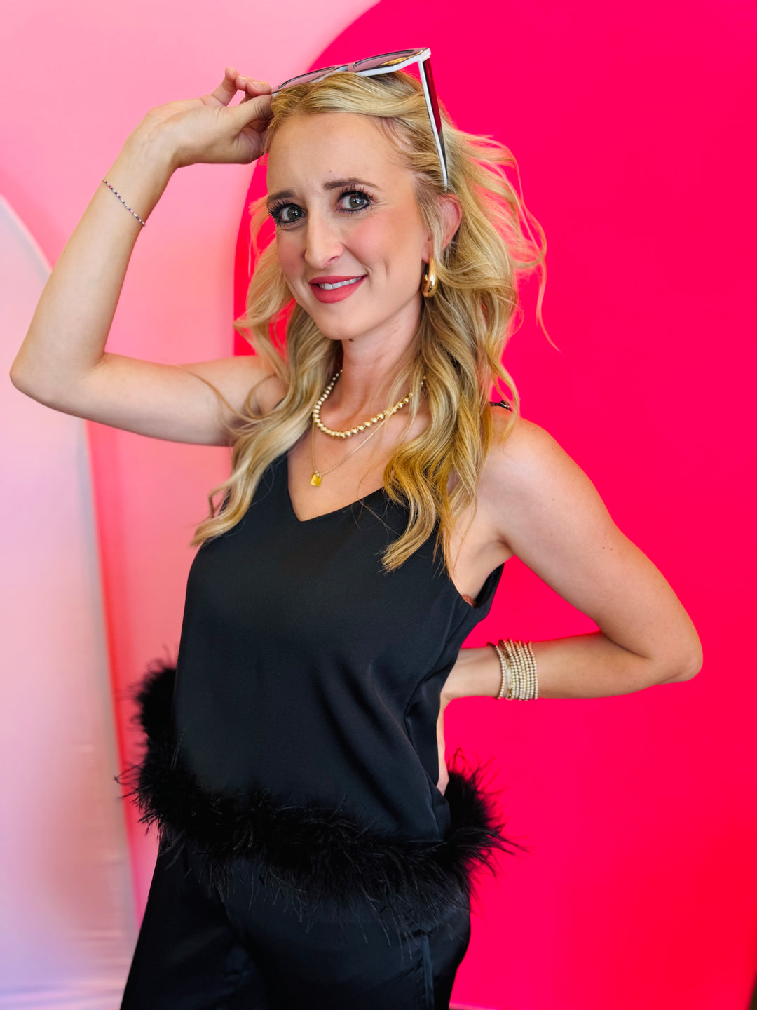 Close-up front view of the Black Feather V-Neck Sleeveless Top highlighting the soft feather trim along the neckline, adjustable straps, and smooth polyester fabric.
