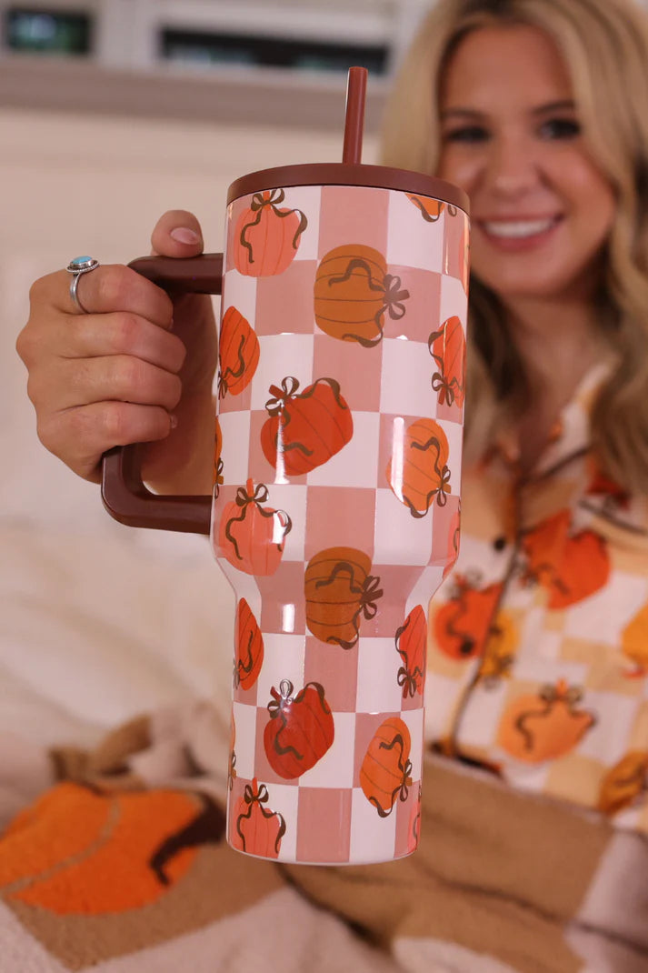 A 40 oz tumbler with a handle, featuring a repeating pattern of pumpkins and bows.