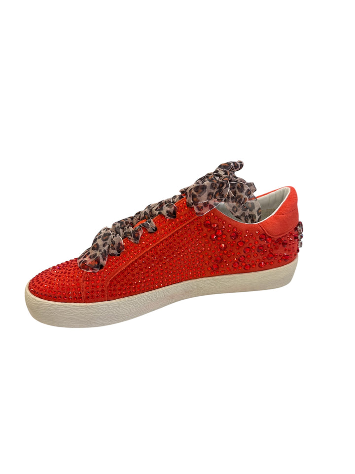 Inner side of red embellished sneaker with clean vegan leather finish and rhinestone embellishments.