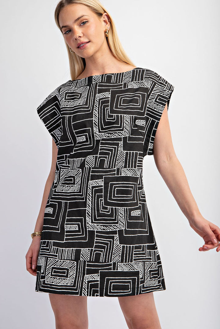 Black and white geometric print mini dress with structured shoulders and an open back.