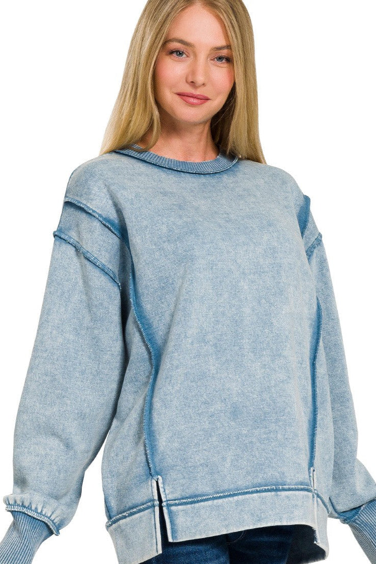 Blue grey acid wash fleece sweatshirt with exposed seams, side slits, and a bottom band.