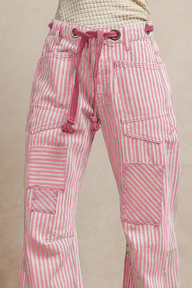 Pink striped twill barrel-leg pants with soft pink rope tie through silver eyelets and decorative front pockets; made from breathable 100% cotton for playful, standout style.
