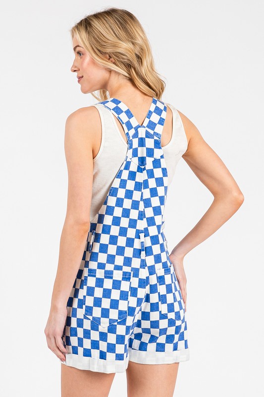 Blue checkered sleeveless romper overalls with adjustable straps, cuffed shorts, and multiple pockets, laid flat to show details.