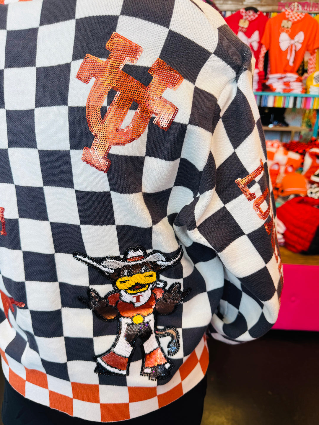 Back view of Queen of Sparkles UT orange and black checkered cardigan with sequin and beading and rhinestone buttons.