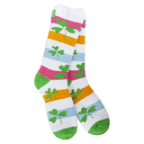 A pair of fuzzy, plush crew socks with a colorful horizontal stripe pattern. Small green shamrocks are scattered across the stripes.