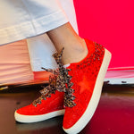 Side profile of red vegan leather sneaker featuring a bold rhinestone star embellishment and slight platform heel with leopard laces.