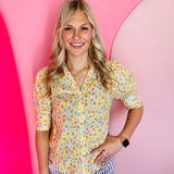 Yellow floral dot button-down top with puff sleeves and tied-back detail in lightweight cotton.