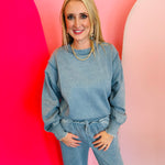 Blue grey acid wash fleece sweatshirt with exposed seams, side slits, and a bottom band.