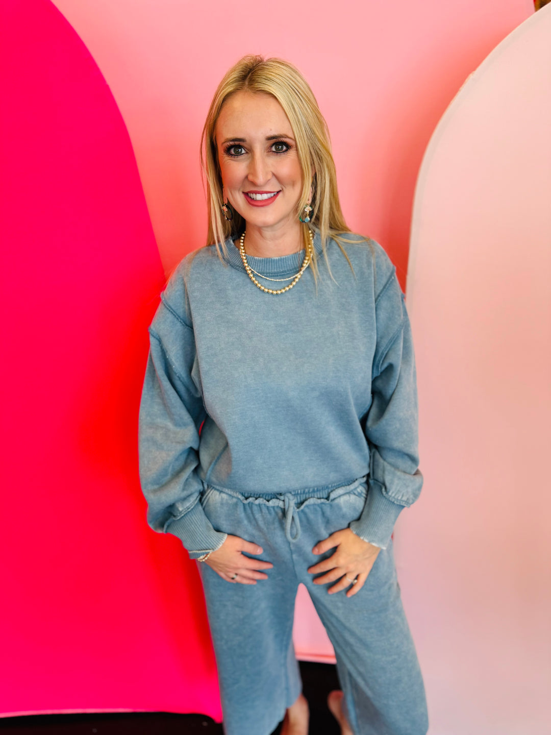 Blue grey acid wash fleece sweatshirt with exposed seams, side slits, and a bottom band.