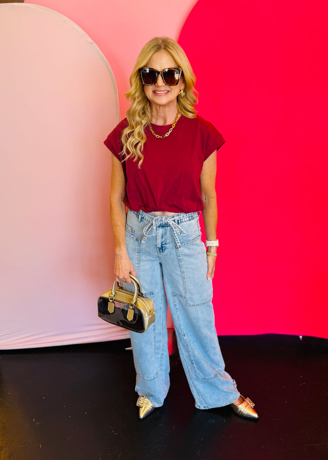 Full-body view of the Blakeley Jovie Tie Waist Jeans styled with a maroon top and sandals, showcasing the relaxed, boho-inspired summer look.