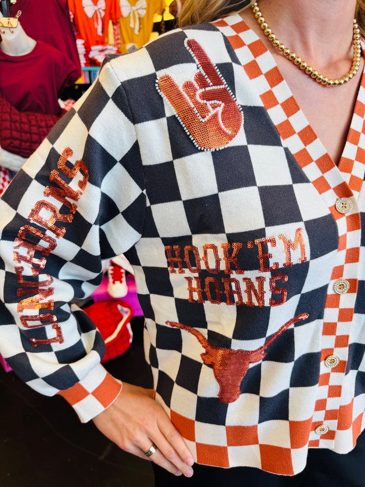 Close up of Queen of Sparkles UT orange and black checkered cardigan with sequin and beading and rhinestone buttons.